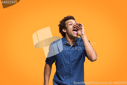 Image of Isolated on blue young casual man shouting at studio