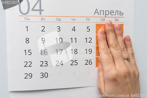 Image of Hand closed the weekend on a sheet of calendar