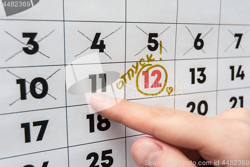 Image of The hand points the finger on the calendar on the last working day before the release