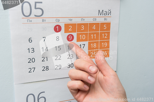 Image of The hand points to the long May holidays holiday in the wall calendar