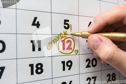 Image of Hand marker on the wall calendar marks the date of the holiday