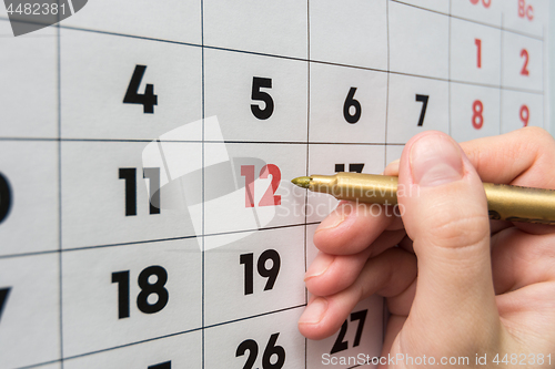 Image of Hand marker indicates the 12th number in the wall calendar