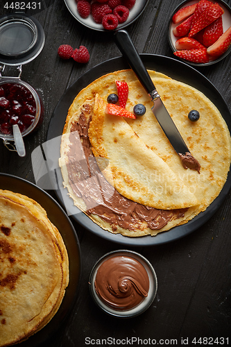 Image of Delicious chocolate homemade pancakes on black ceramic plate