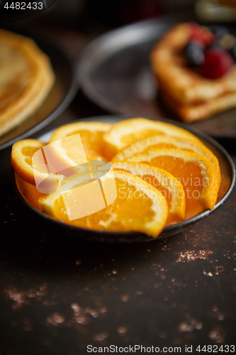 Image of Close up on fresh orange slices placed on ceramic saucer