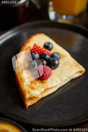 Image of Tasety homemade pancake on black ceramic plate.