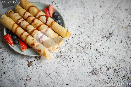 Image of Plate of delicious crepes roll with fresh fruits and chocolate