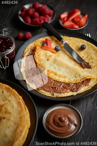 Image of Delicious chocolate homemade pancakes on black ceramic plate