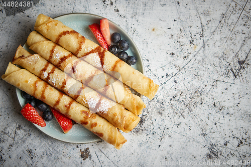 Image of Plate of delicious crepes roll with fresh fruits and chocolate