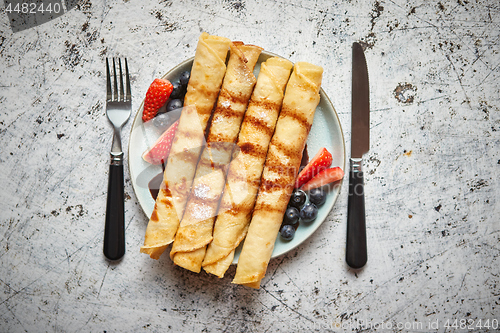 Image of Plate of delicious crepes roll with fresh fruits and chocolate