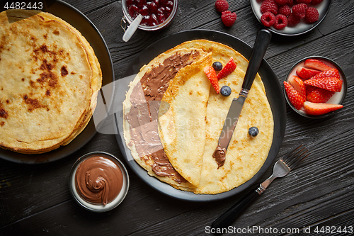 Image of Delicious chocolate homemade pancakes on black ceramic plate