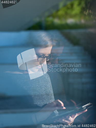 Image of Woman using tablet at home by the window