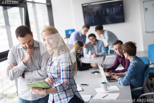 Image of Two Business People Working With Tablet in office