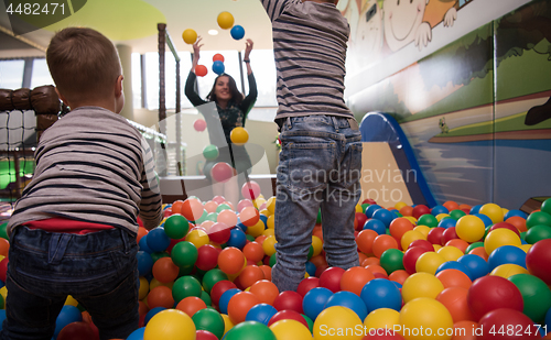 Image of Young mom with her kids in a children\'s playroom