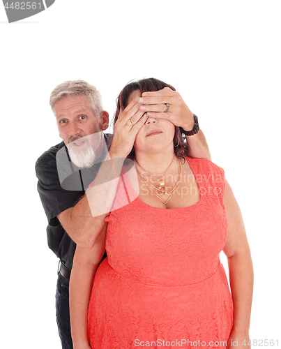 Image of Man holds hands over wife's eyes