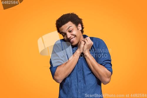 Image of Handsome man looking suprised isolated on orange