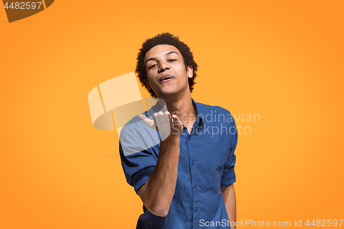 Image of Portrait of attractive afro man with kiss isolated over orange background