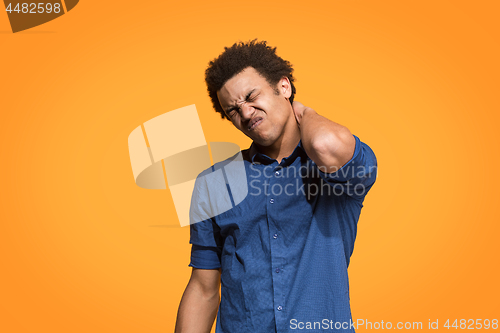 Image of Young man overwhelmed with a pain in the necks