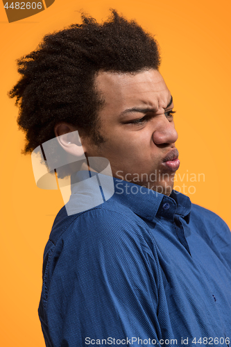 Image of Let me think. Doubtful pensive man with thoughtful expression making choice against orange background