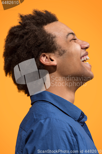 Image of The happy business man standing and smiling against orange background.