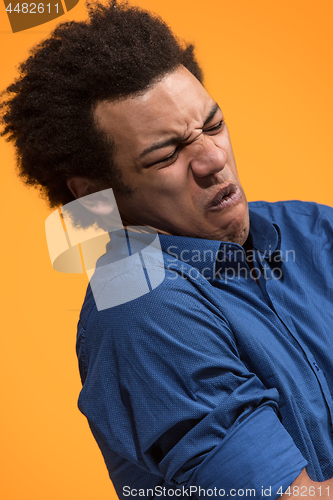 Image of Let me think. Doubtful pensive man with thoughtful expression making choice against orange background