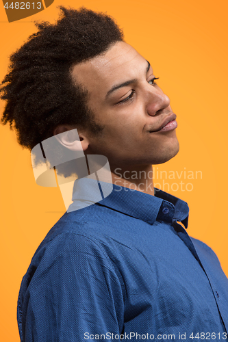 Image of Beautiful male half-length portrait isolated on orange studio backgroud. The young emotional surprised man