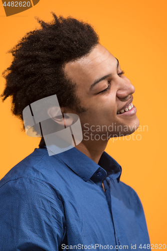 Image of The happy business man standing and smiling against orange background.