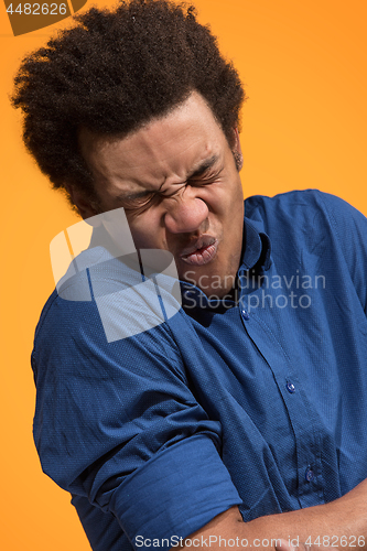 Image of Let me think. Doubtful pensive man with thoughtful expression making choice against orange background