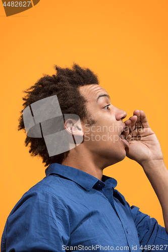 Image of Isolated on orange young casual man shouting at studio