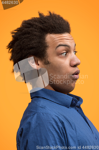 Image of The young attractive man looking suprised isolated on orange