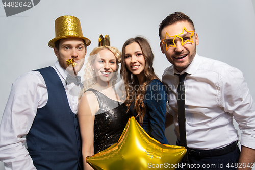 Image of happy friends with golden party props posing