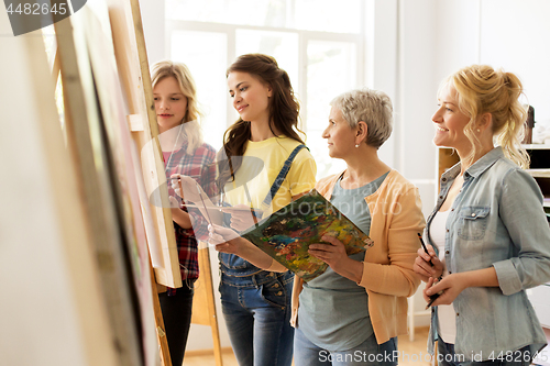 Image of women with brushes painting at art school