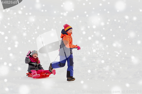 Image of girls with sled having fun outdoors in winter