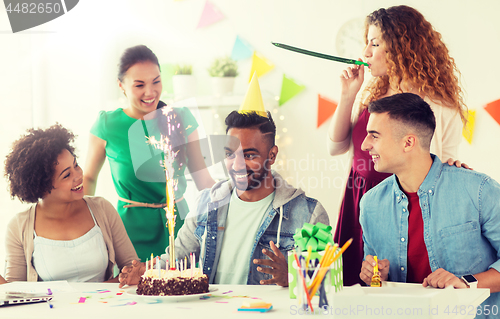 Image of team greeting colleague at office birthday party