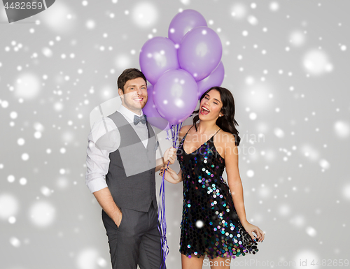 Image of happy couple with ultra violet balloons at party