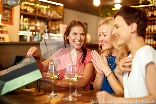 Image of women with shopping bags at wine bar or restaurant