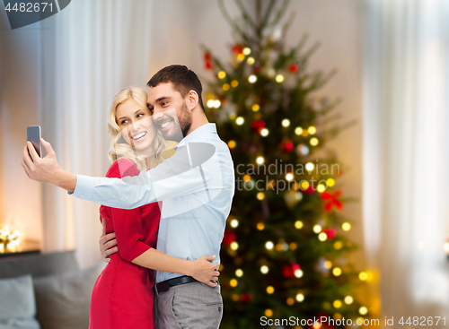 Image of couple taking selfie by smartphone on christmas