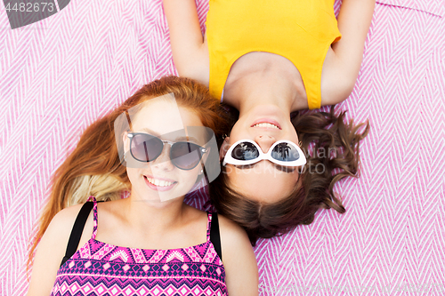 Image of teenage girls in sunglasses on picnic blanket