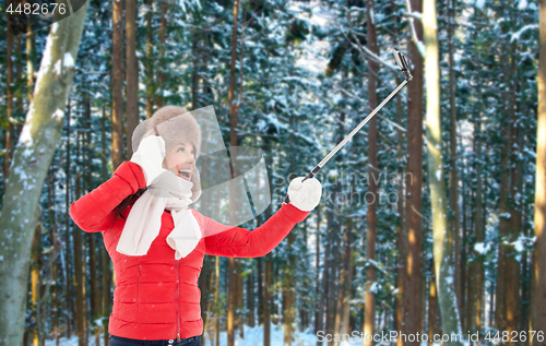 Image of happy woman taking selfie over winter forest