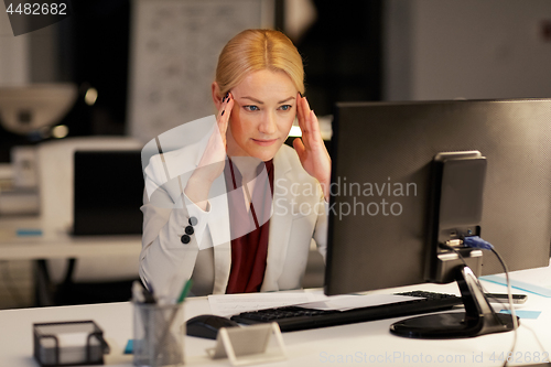 Image of businesswoman with computer at night office