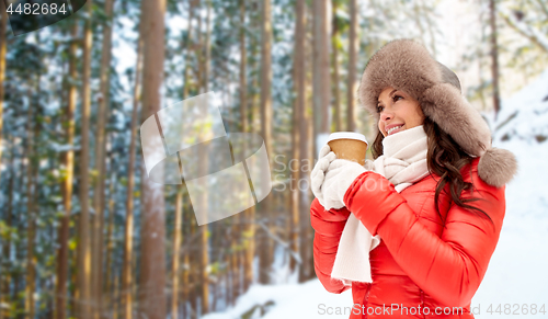Image of woman in fur hat with coffee over winter forest