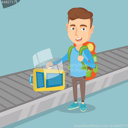 Image of Man takes a suitcase on luggage conveyor belt.