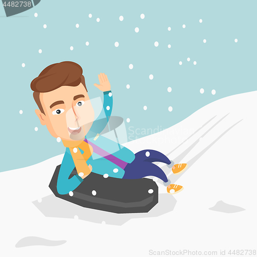 Image of Man sledding on snow rubber tube in the mountains.