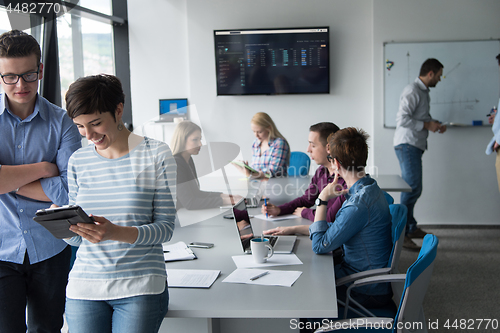 Image of Two Business People Working With Tablet in office