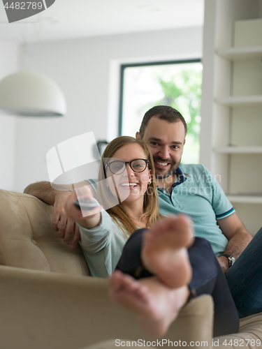 Image of Young couple on the sofa watching television