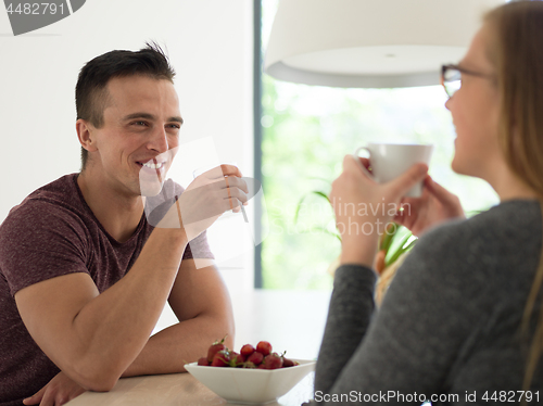 Image of couple enjoying morning coffee and strawberries