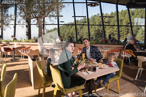 Image of Young parents enjoying lunch time with their children