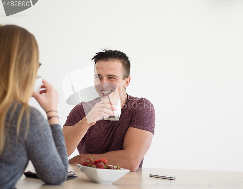 Image of couple enjoying morning coffee and strawberries