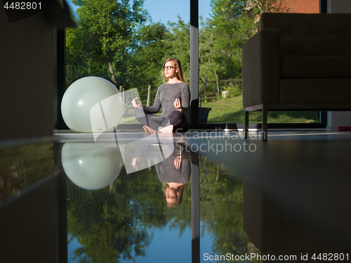 Image of young woman doing morning yoga exercises