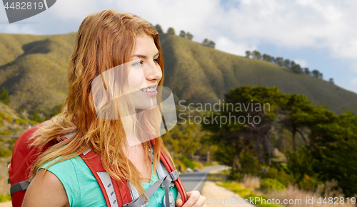 Image of smiling woman with backpack on big sur hills