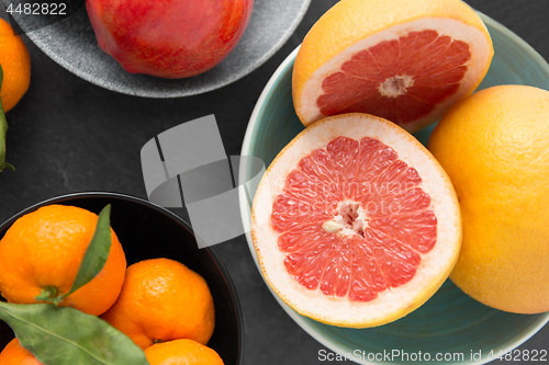 Image of close up of citrus in bowls fruits on stone table